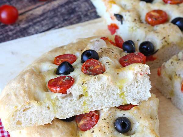 Ta gruba focaccia z pomidorkami koktajlowymi i oliwkami urzeka już samym zapachem: przepis, który warto wypróbować