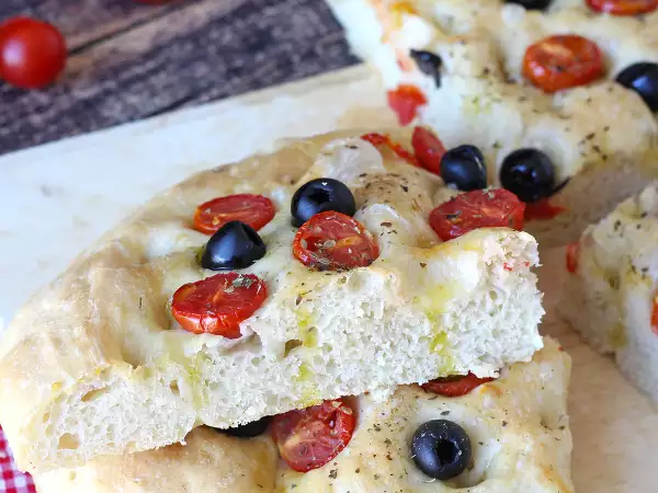 Ta gruba focaccia z pomidorkami koktajlowymi i oliwkami urzeka już samym zapachem: przepis, który warto wypróbować