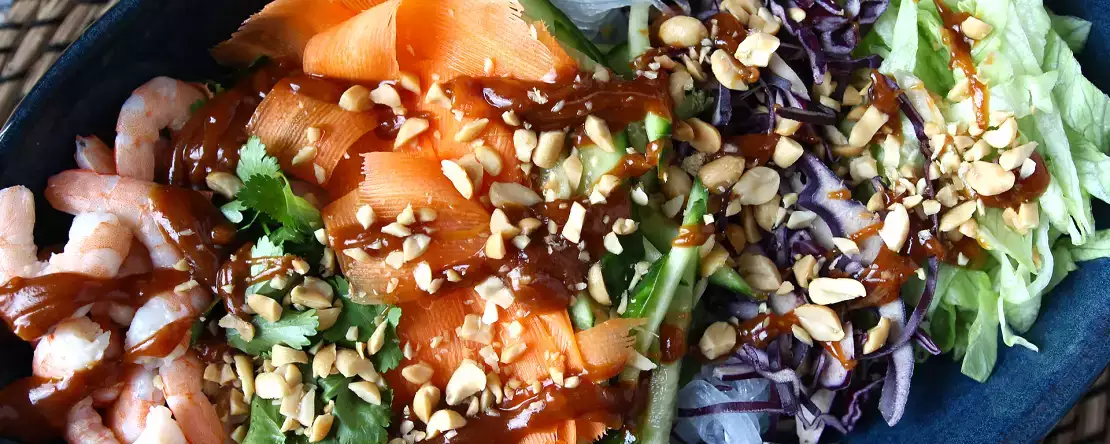 Kolorowa sałatka z makaronem ryżowym i krewetkami oraz pikantnym sosem orzechowym