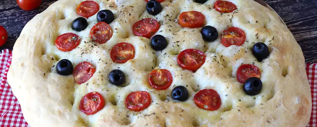 Gruba i puszysta focaccia z pomidorkami koktajlowymi, oliwkami i oregano