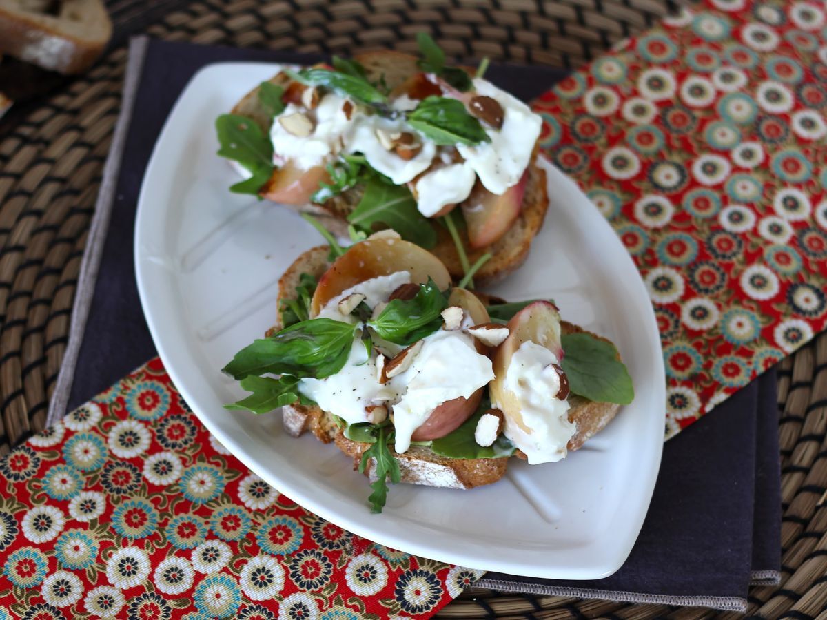 Rukola, pieczone brzoskwinie i burrata na grzance: idealne słodko-słone połączenie!